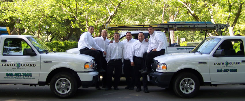 pest professionals at Earth Guard with white service trucks